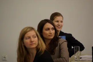 Drei Frauen sitzen in einer Reihe und schauen hoch